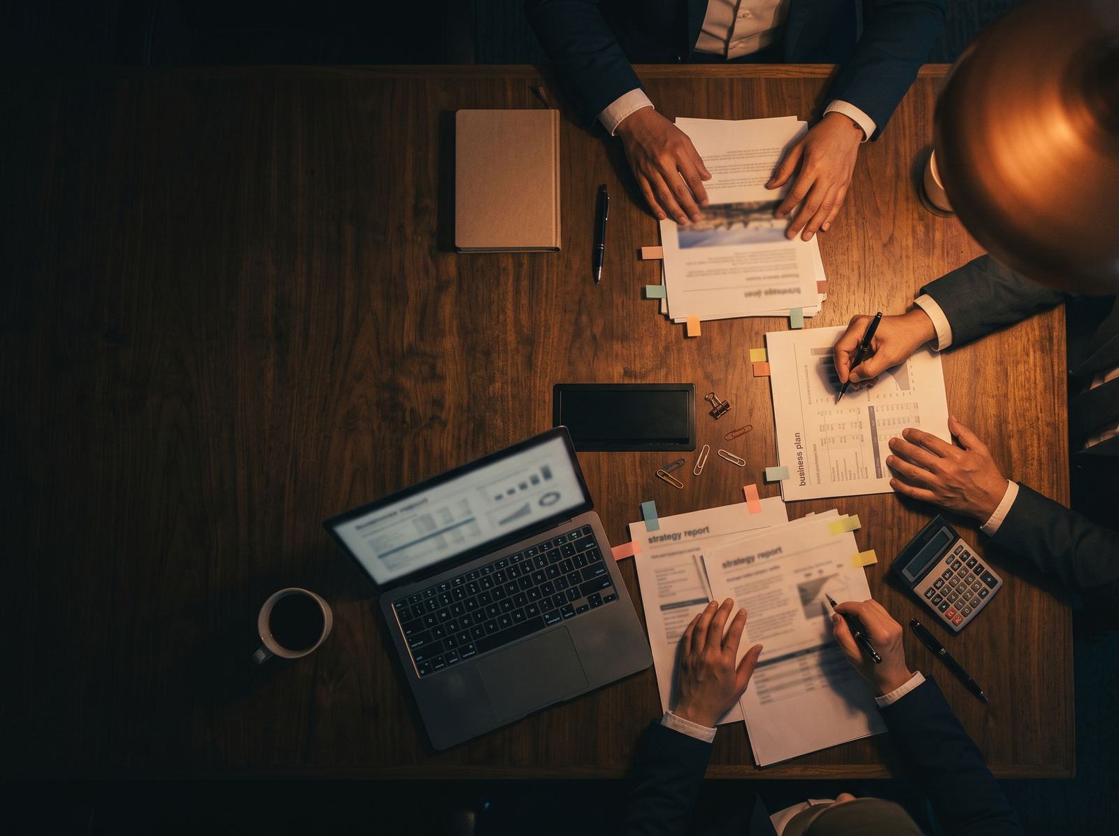 Seen from above: several people working through papers and a laptop on a table